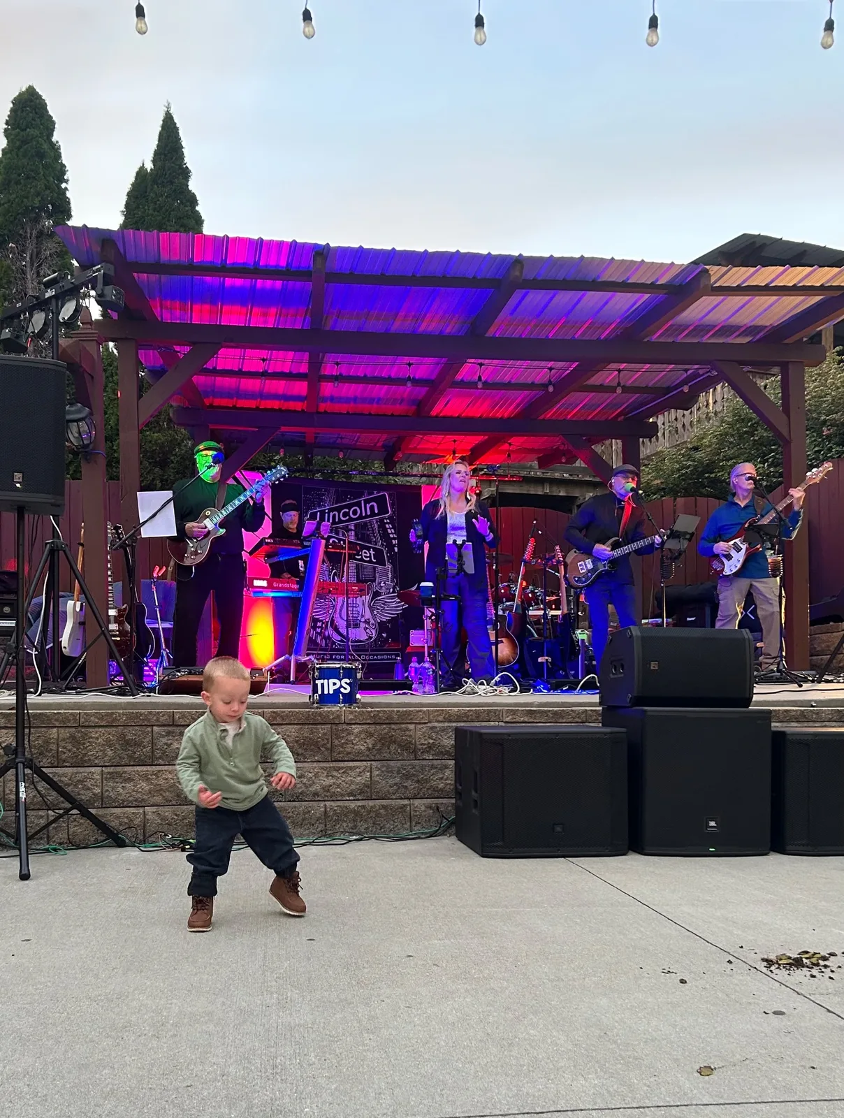 Lincoln Street Band performing while a young fan dances in front of the stage